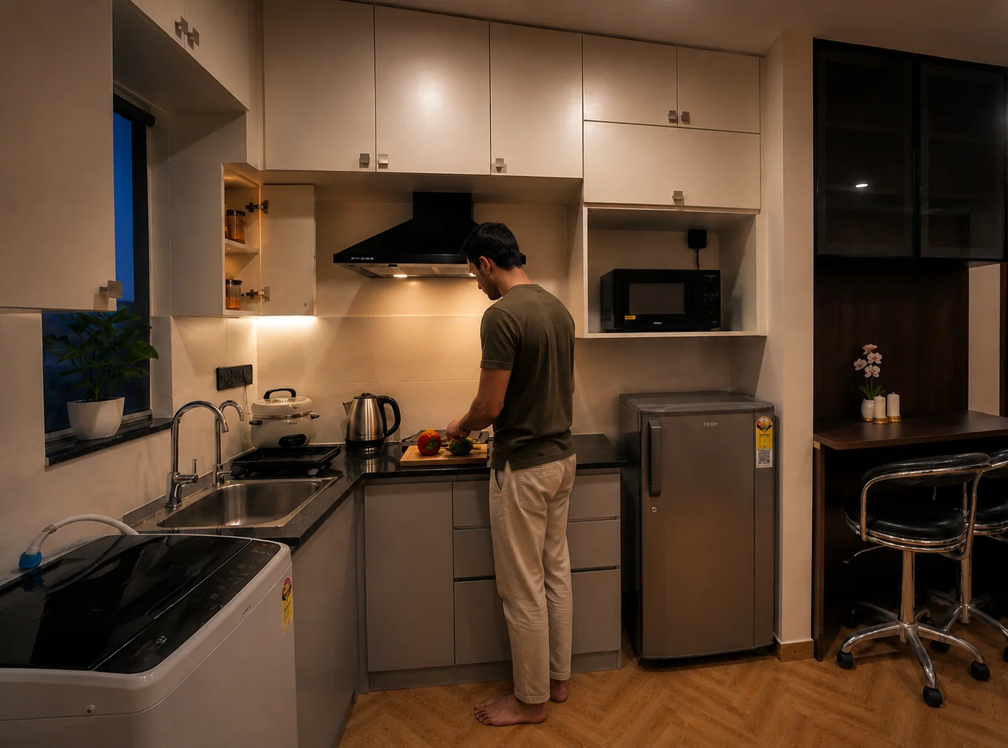Guest preparing a meal in the real LuxStayz 1BHK kitchen
