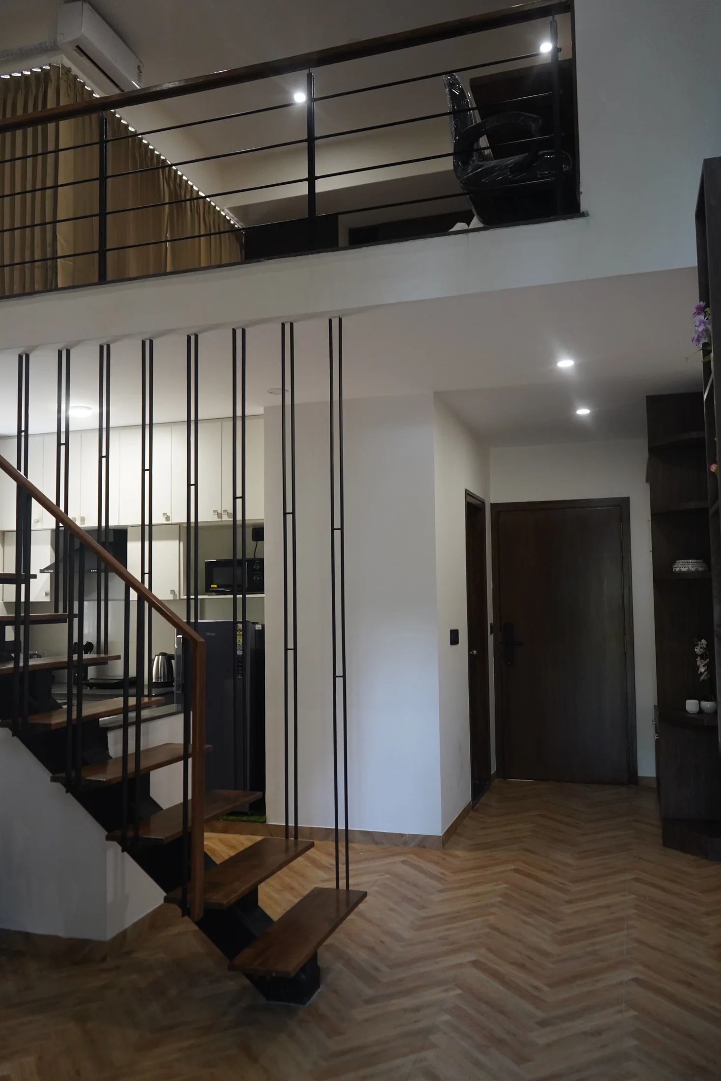 Staircase and upper-level railing inside a LuxStayz Loft apartment